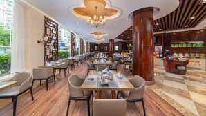 Ein geräumiges Restaurant mit hohen Decken, Kronleuchtern und verschiedenen Sitzmöglichkeiten.
