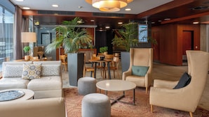 Una hall d'albergo con un'area salotto, una reception e una scala.