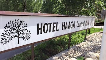 Señal del Hotel Haaga Central Park con un logo de árbol.