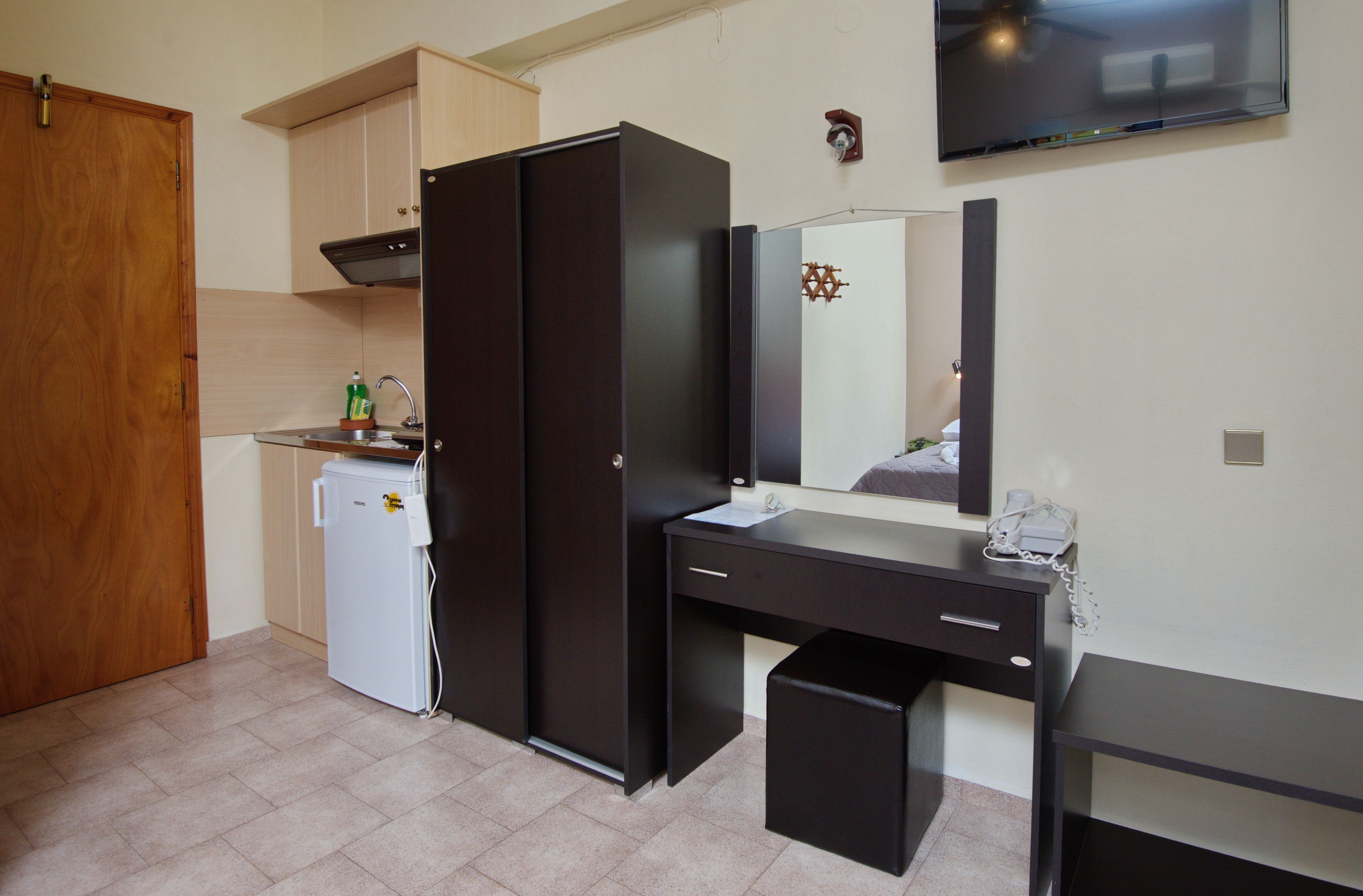 Una cocina compacta con refrigerador, lavamanos y encimera.