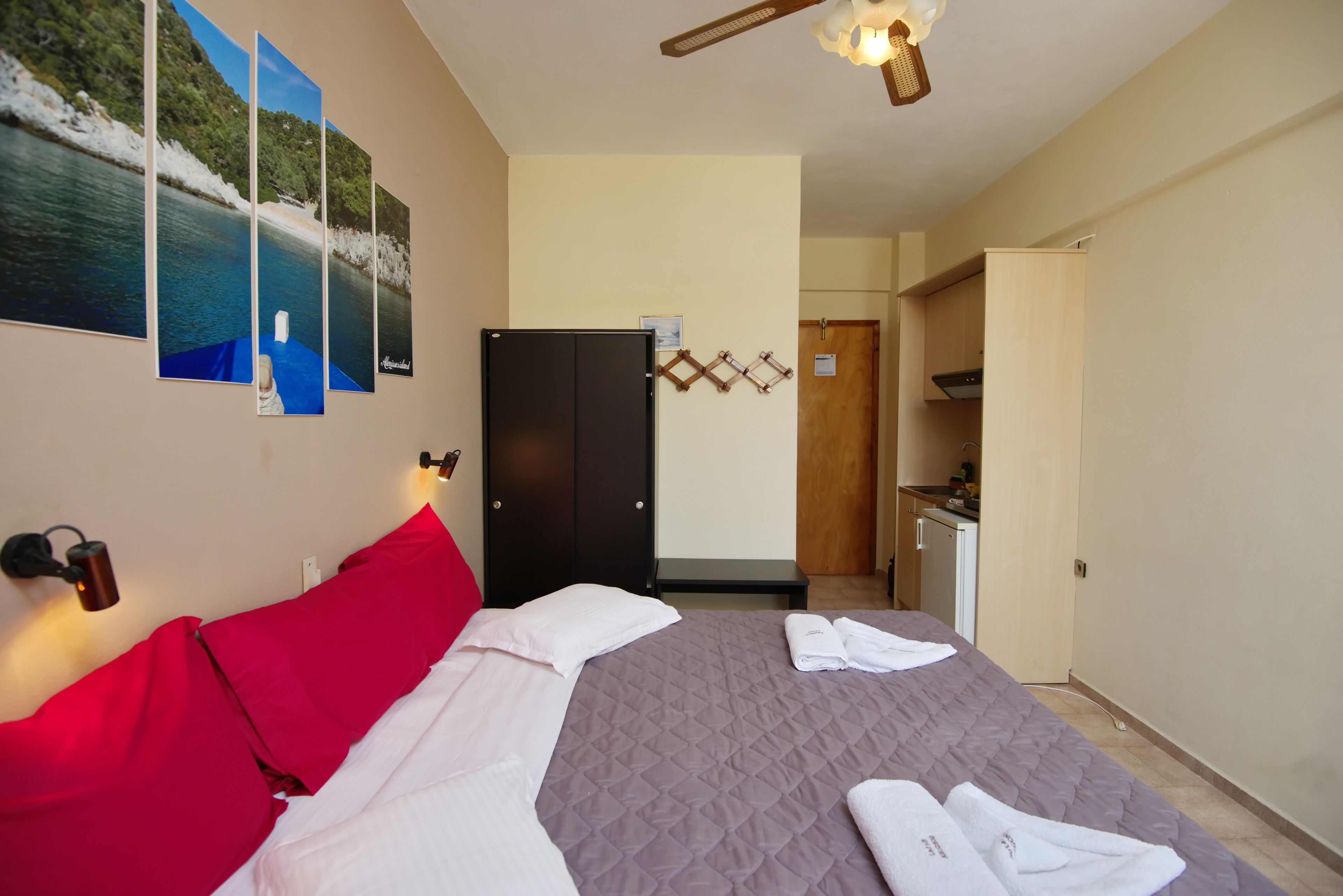 A hotel room with a bed, a wardrobe, a desk, and a bathroom.