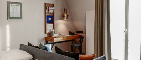 Une chambre à coucher comprenant un lit, un bureau, une chaise, une lampe et une porte-fenêtre coulissante.