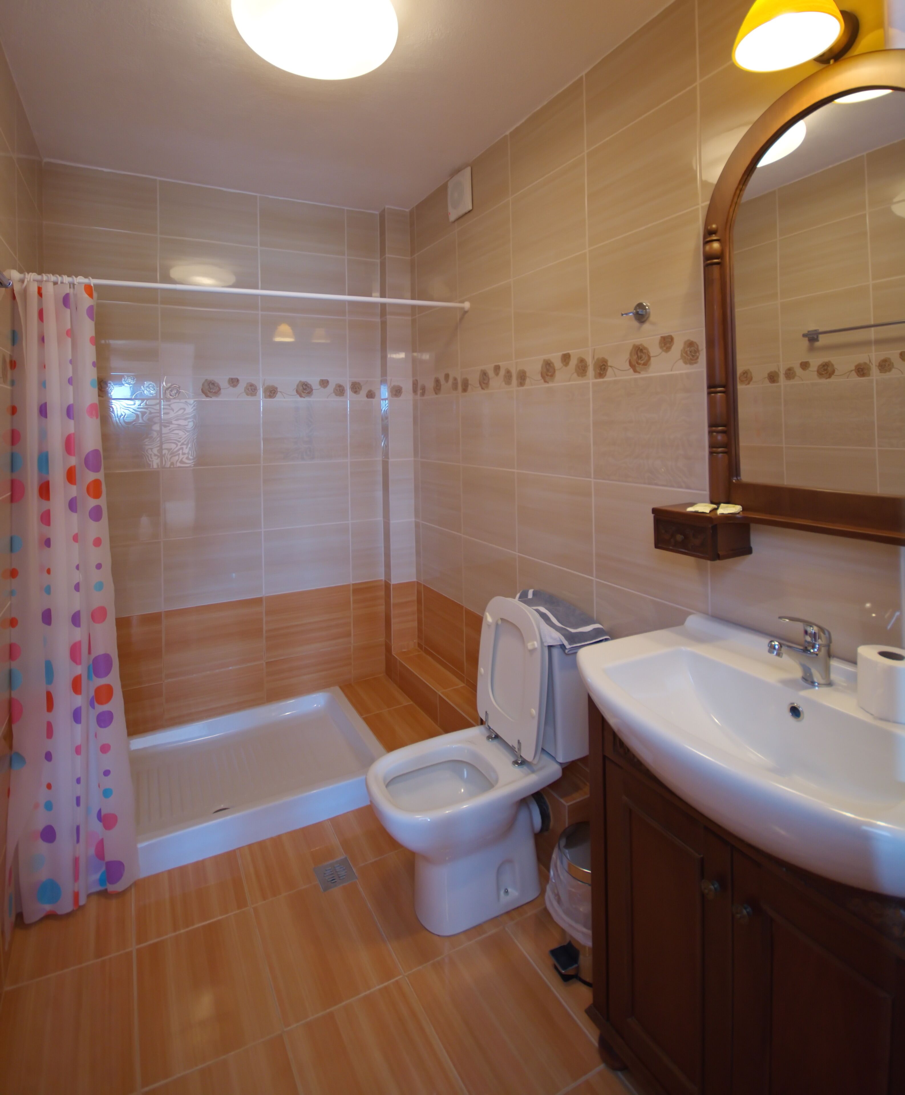 A bathroom with a shower, toilet, and sink.