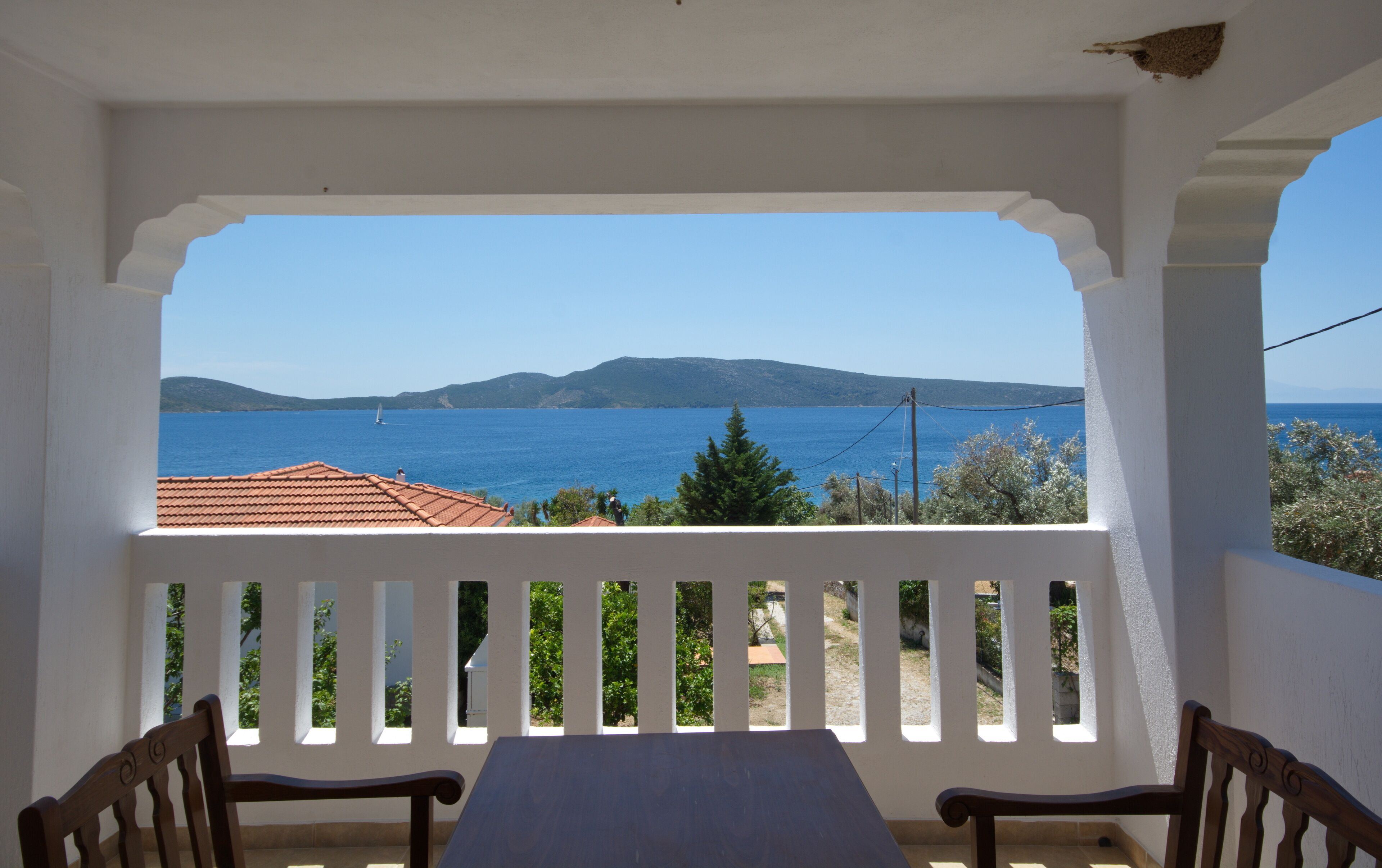 A balcony with a view of the sea and mountains.