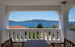 Un balcón con vista al mar y a las montañas.