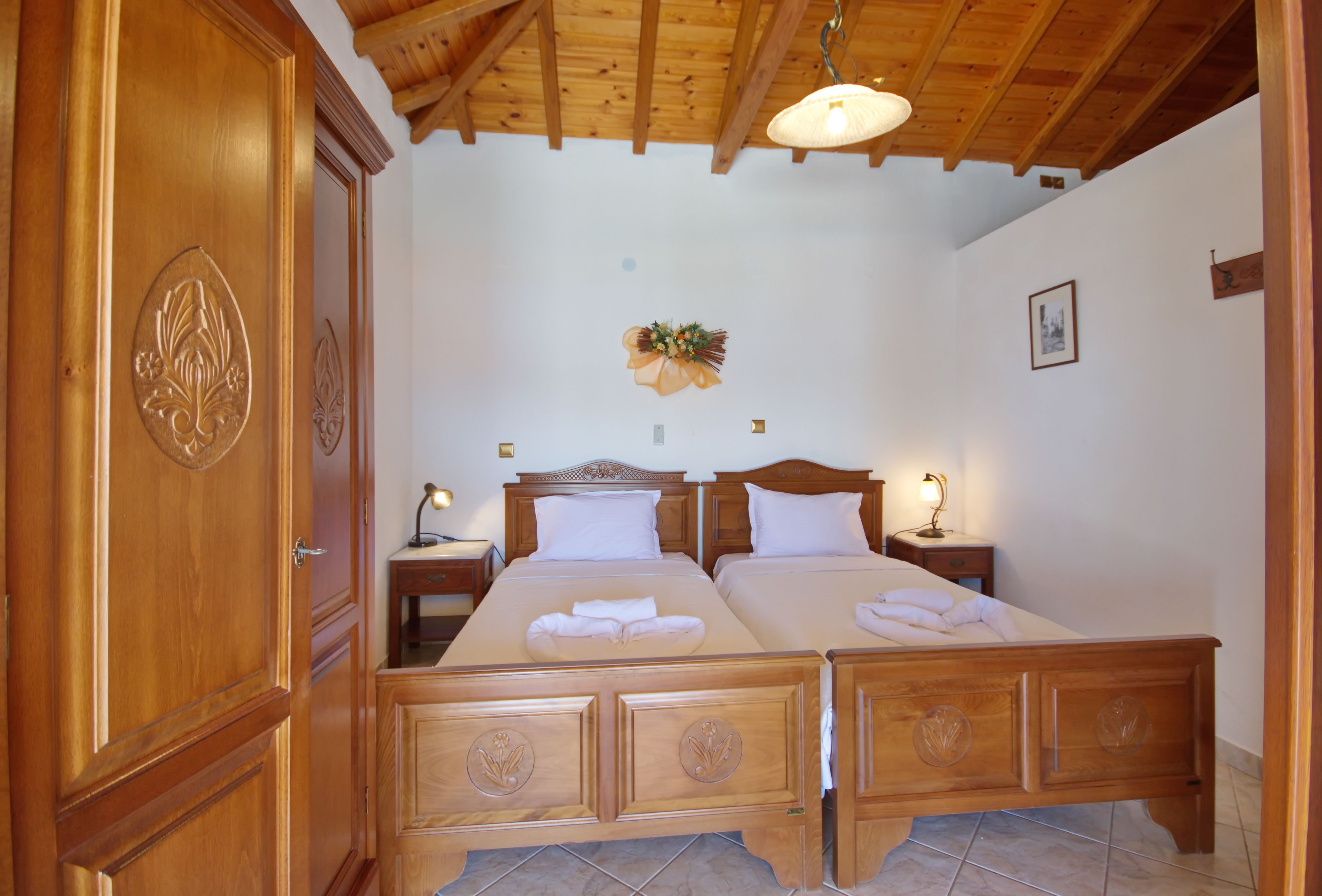A double bed with wooden headboards and a wooden wardrobe.