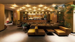 A bar area with a neon sign, seating arrangements, and potted plants.