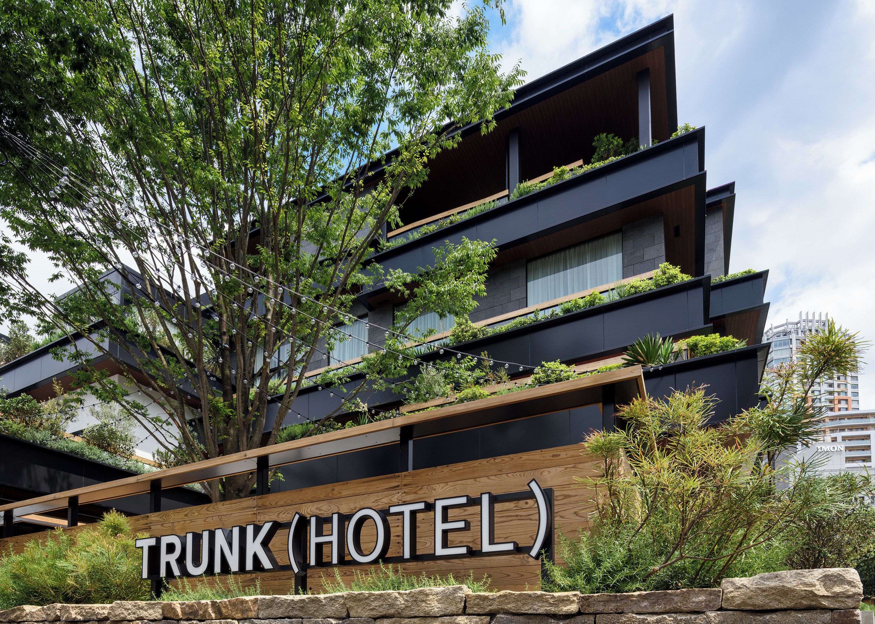 Een modern hotel met een bord waarop 'TRUNK HOTEL' staat.