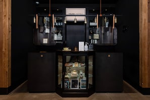 A hotel reception area with a dark interior, a reception desk, and a display case containing various items.