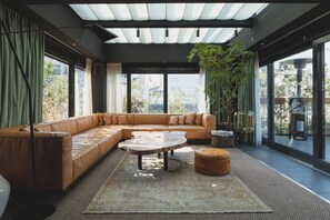 Una sala de estar moderna con un sofá modular, una mesa de centro y un amplio ventanal con vistas al exterior.
