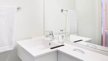 Une salle de bain moderne avec deux lavabos, un grand miroir et un porte-serviettes.
