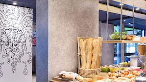 A breakfast buffet with bread, pastries, and a toaster. - ibis budget Thonon Les Bains (Thonon-les-Bains)