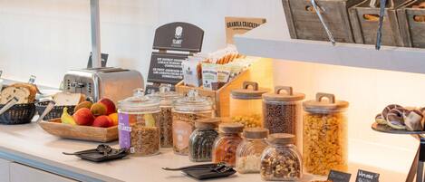 Un bufé de desayuno con diversos alimentos y utensilios.