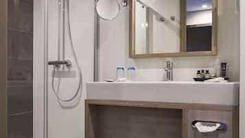 Une salle de bain moderne avec une douche à parois de verre, un meuble-lavabo avec un miroir et un évier.