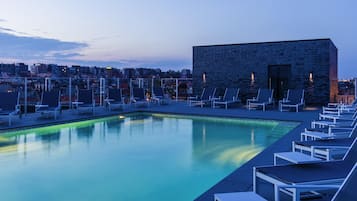 Piscine extérieure en saison, chaises longues