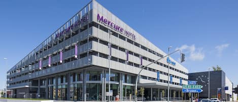 Located at the intersection of E40 and E403, Mercure Hotel features a distinctive triangular roof and a prominent facade.