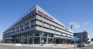 Ein modernes Hotel mit einem gut sichtbaren Schild, auf dem „Mercure Hotel“ steht.