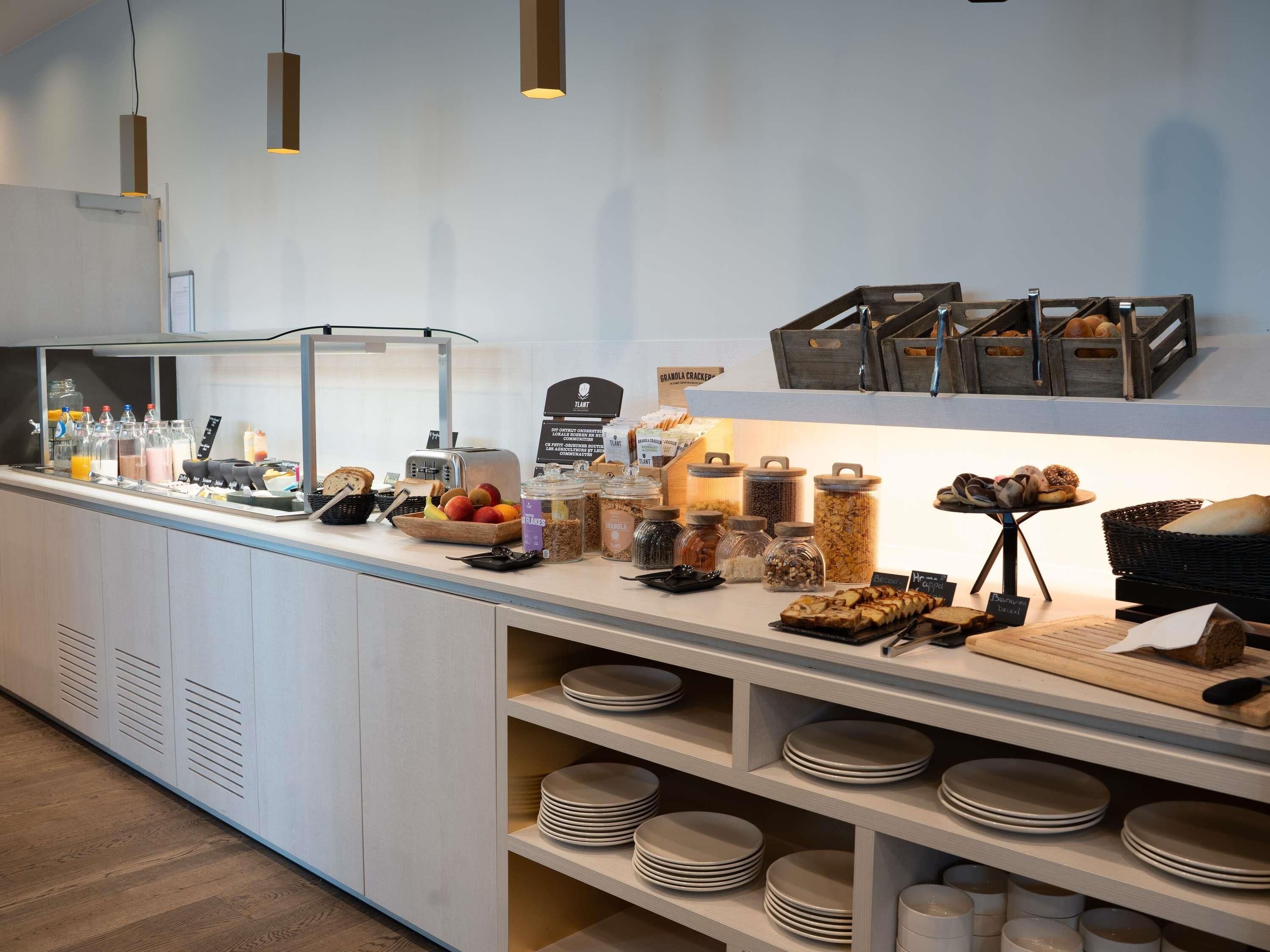 A buffet area with various food items, including fruits, cereals, and bread.