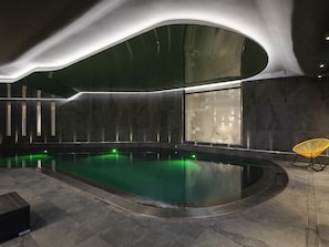 Una piscina cubierta, tumbonas