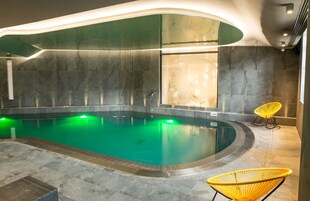 Una piscina techada, sillones reclinables de piscina