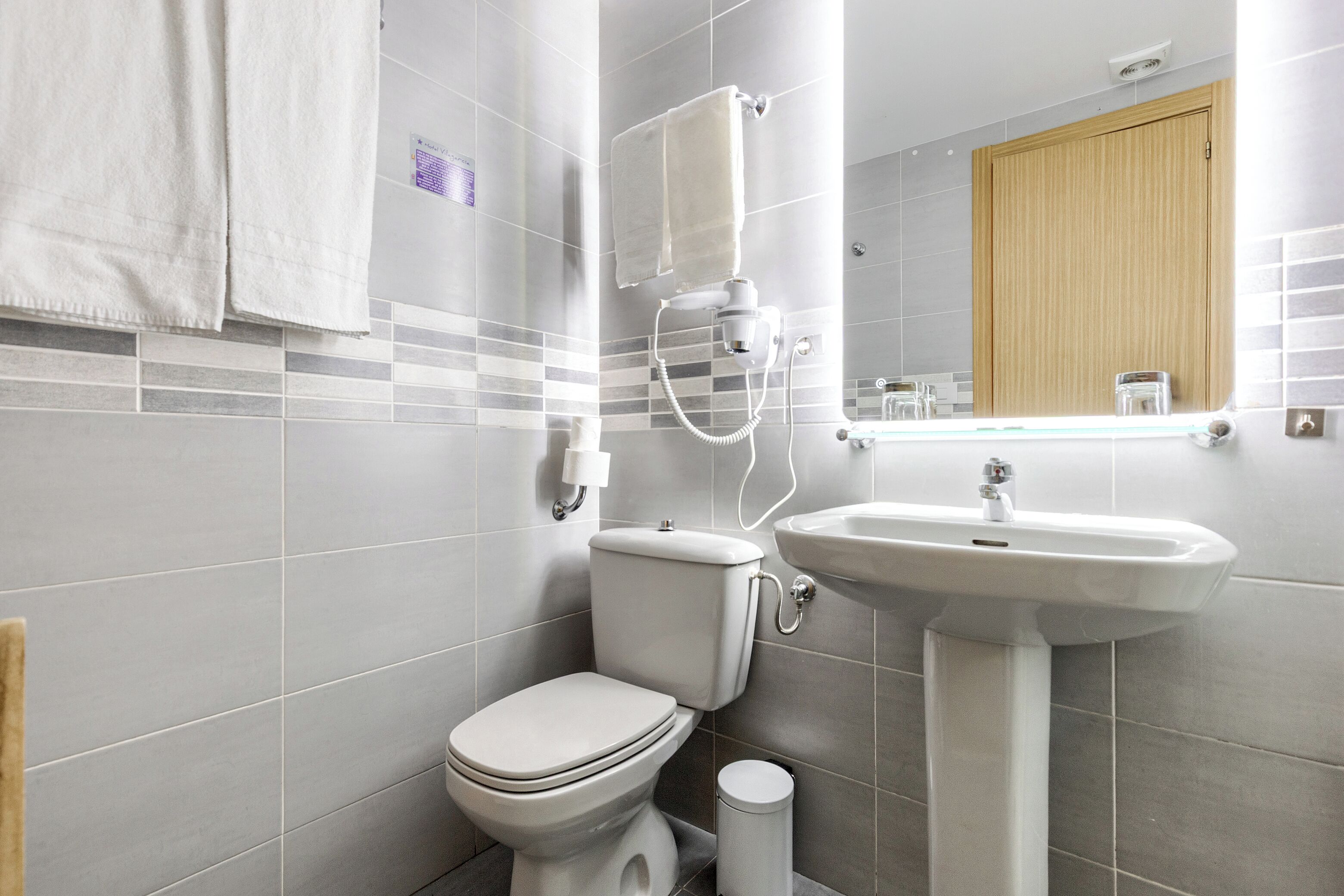 A modern bathroom with a toilet, sink, and towel rack.