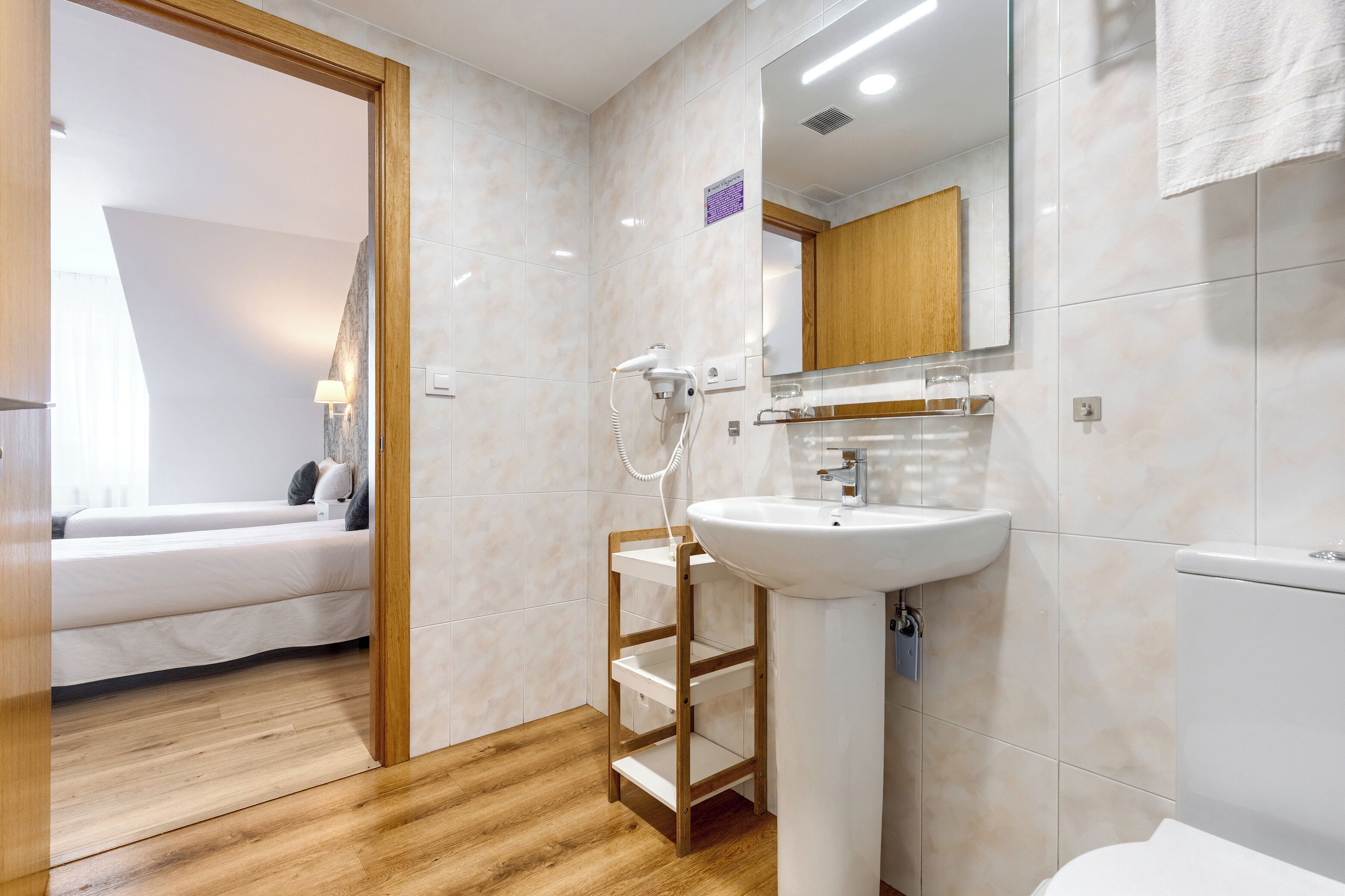 Een moderne badkamer met een wastafel, spiegel en douche.