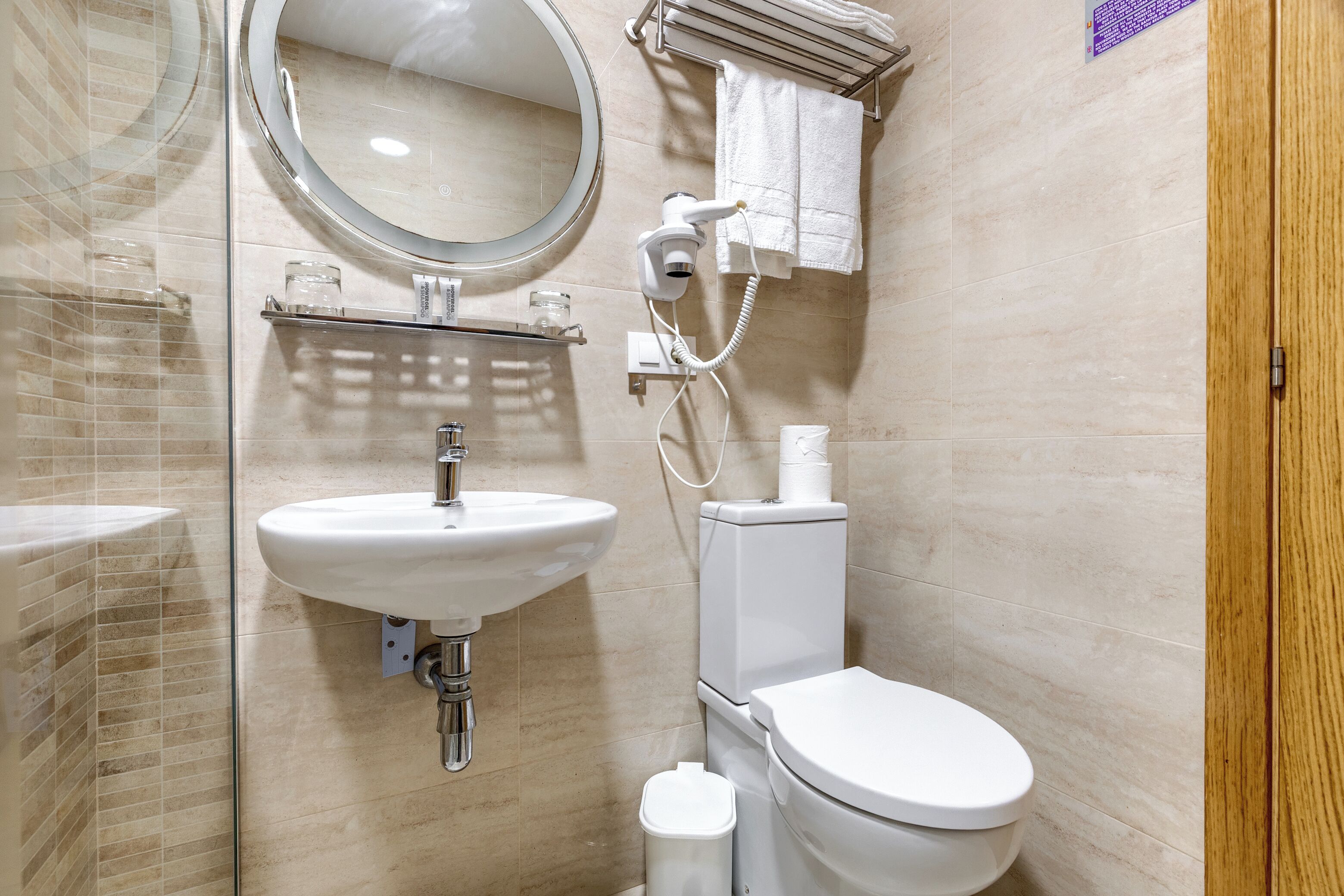 A bathroom with a sink, mirror, toilet, and towel rack.