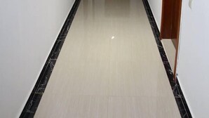 A long, narrow hallway with a polished floor, white walls, and wooden doors. - Hotel Park Green (Poti)