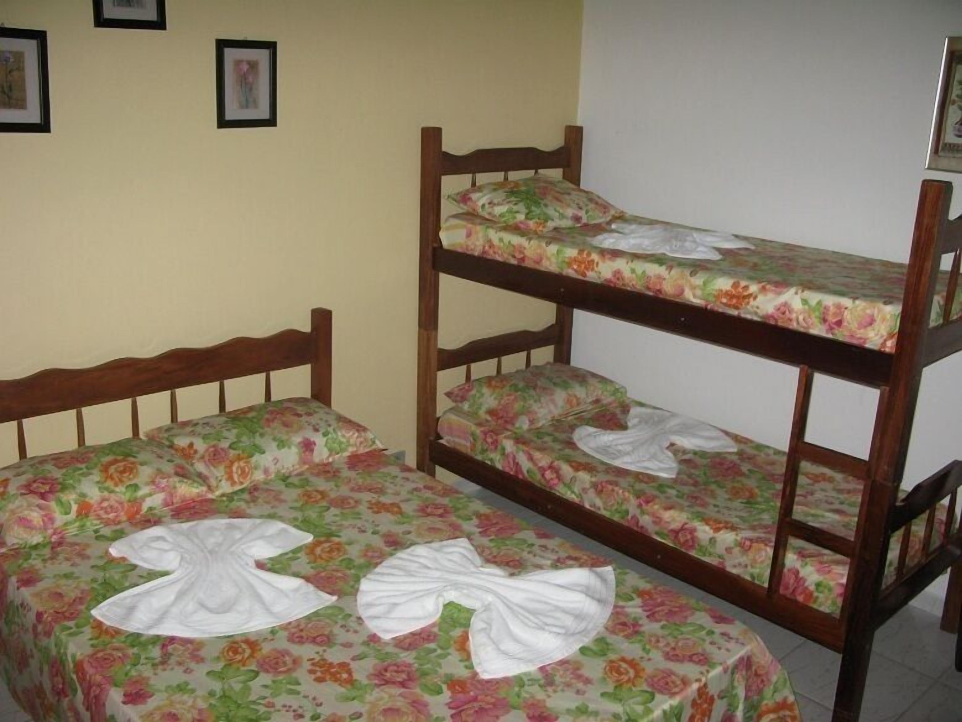 Uma cama beliche com roupa de cama florida e cabeceira de madeira.