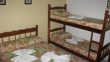 Uma cama beliche com roupa de cama florida e cabeceira de madeira.