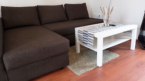 Un sofá seccional marrón con una mesa de centro blanca.