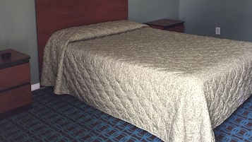 Quarto com cama, duas mesas de cabeceira e luminária fixada na parede.