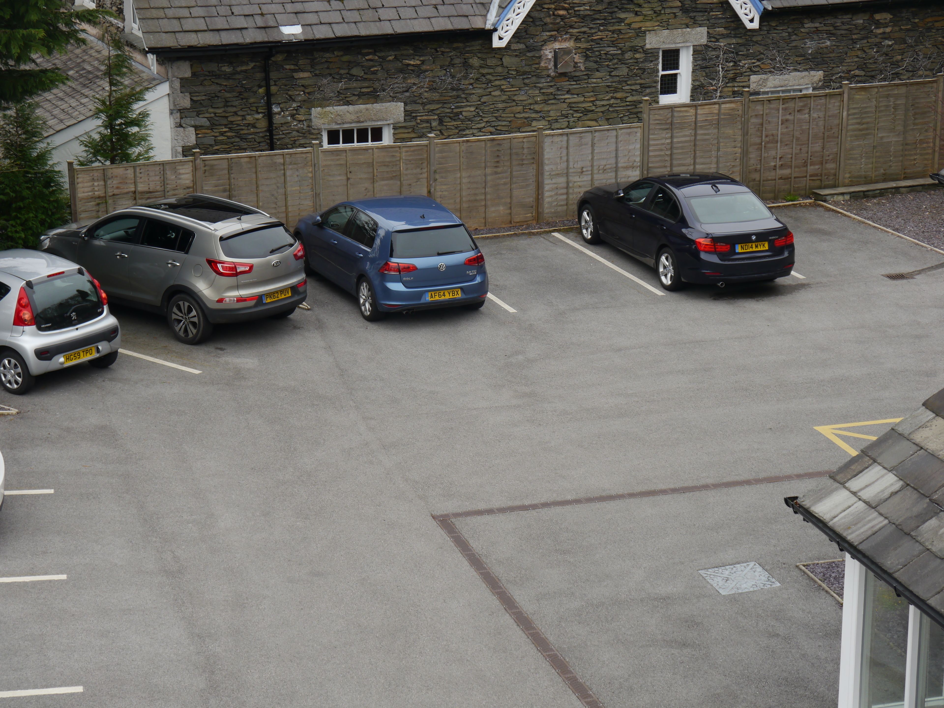 A parking lot with five cars parked in a row.
