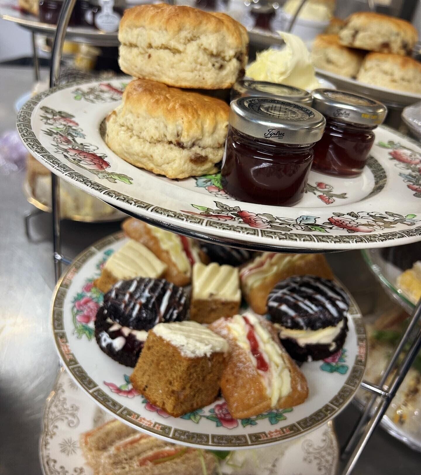 Un plateau à étages pour servir, avec des scones, de la confiture et un assortiment de viennoiseries.