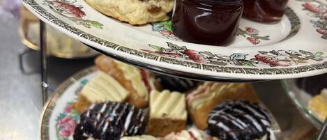 Un plateau à étages pour servir, avec des scones, de la confiture et un assortiment de viennoiseries.