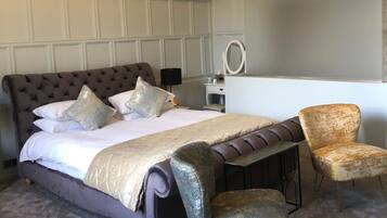 A bedroom with a large bed, a desk, and a chair.