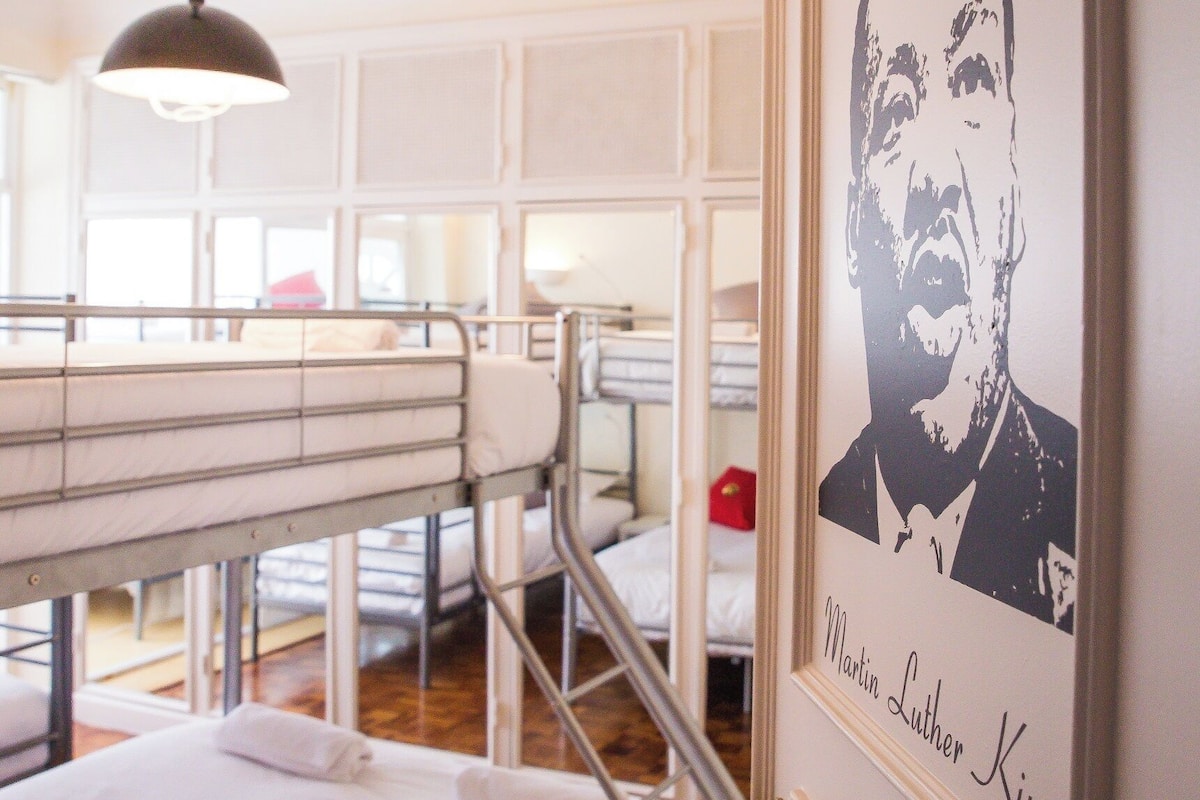 Dormitorio con literas y un retrato enmarcado de Martin Luther King Jr. en la pared.