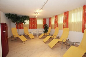 Ein Konferenzraum mit gelben Stühlen, einem Tisch und roten Vorhängen.