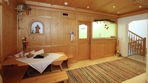 A wooden interior with a bed, bedside table, and a window with a view.