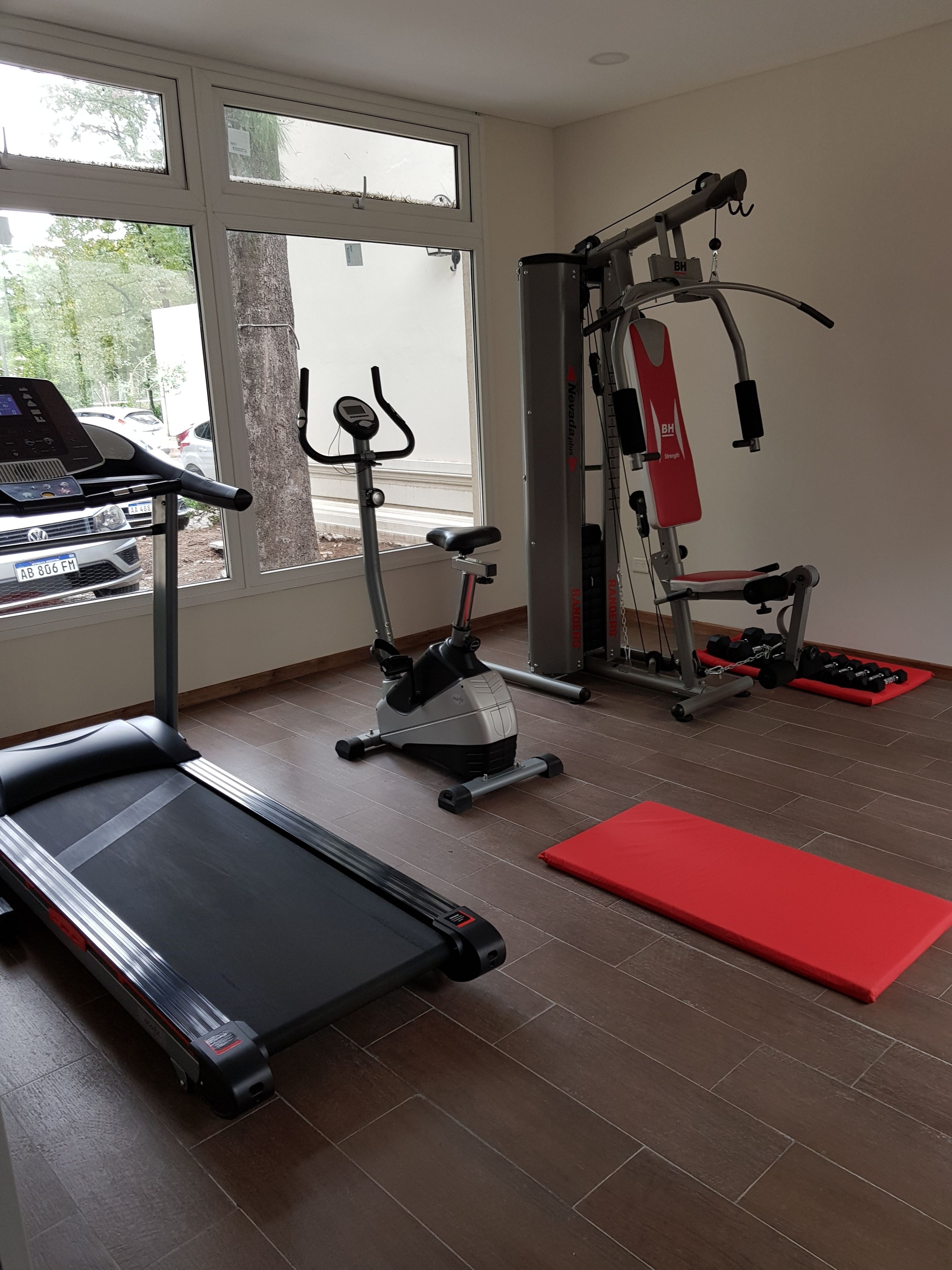 Une salle de sport équipée de tapis de course, de vélos elliptiques et d’appareils de musculation.