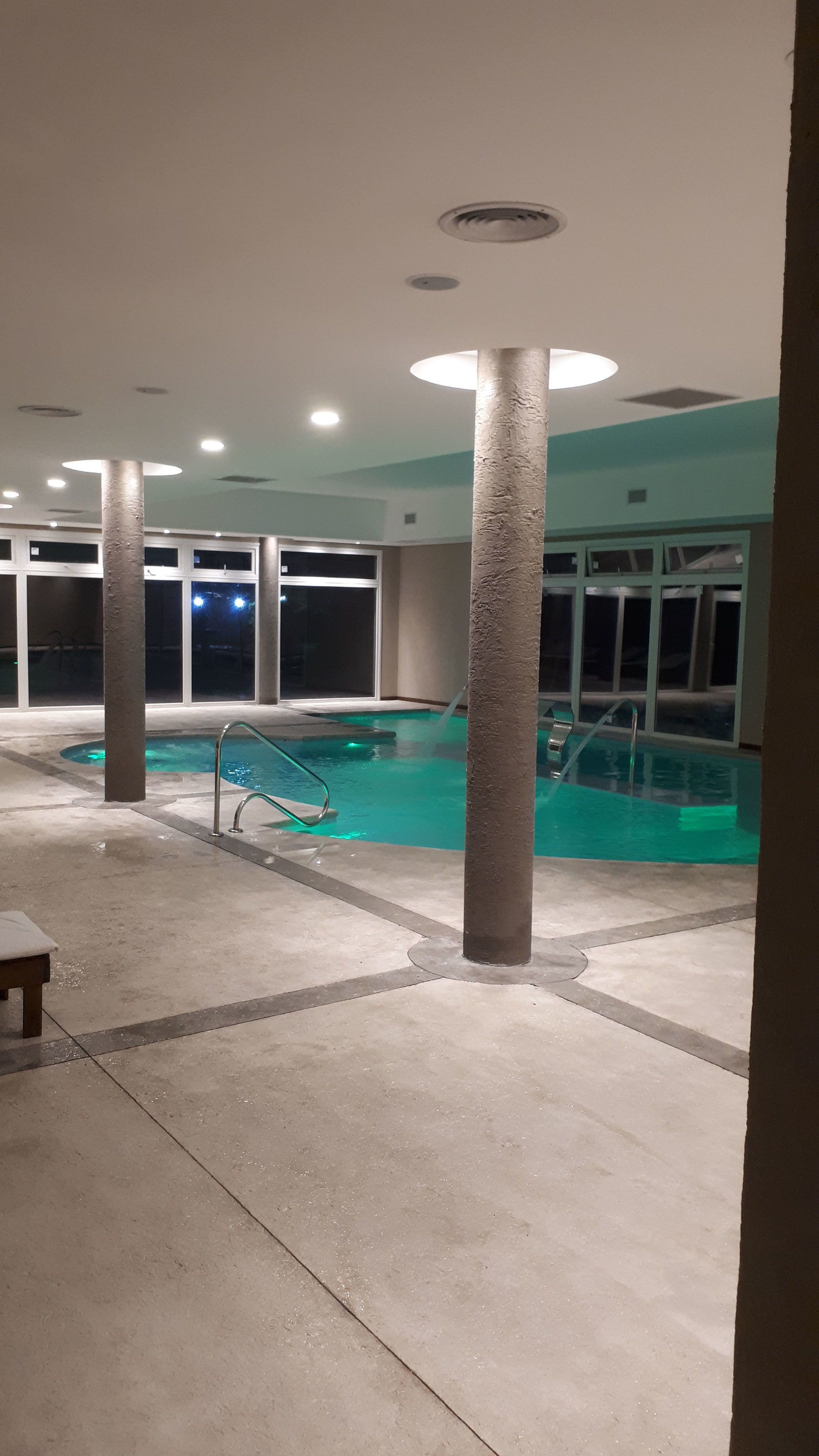 Un espace piscine comprenant une piscine, un plongeoir et un banc.