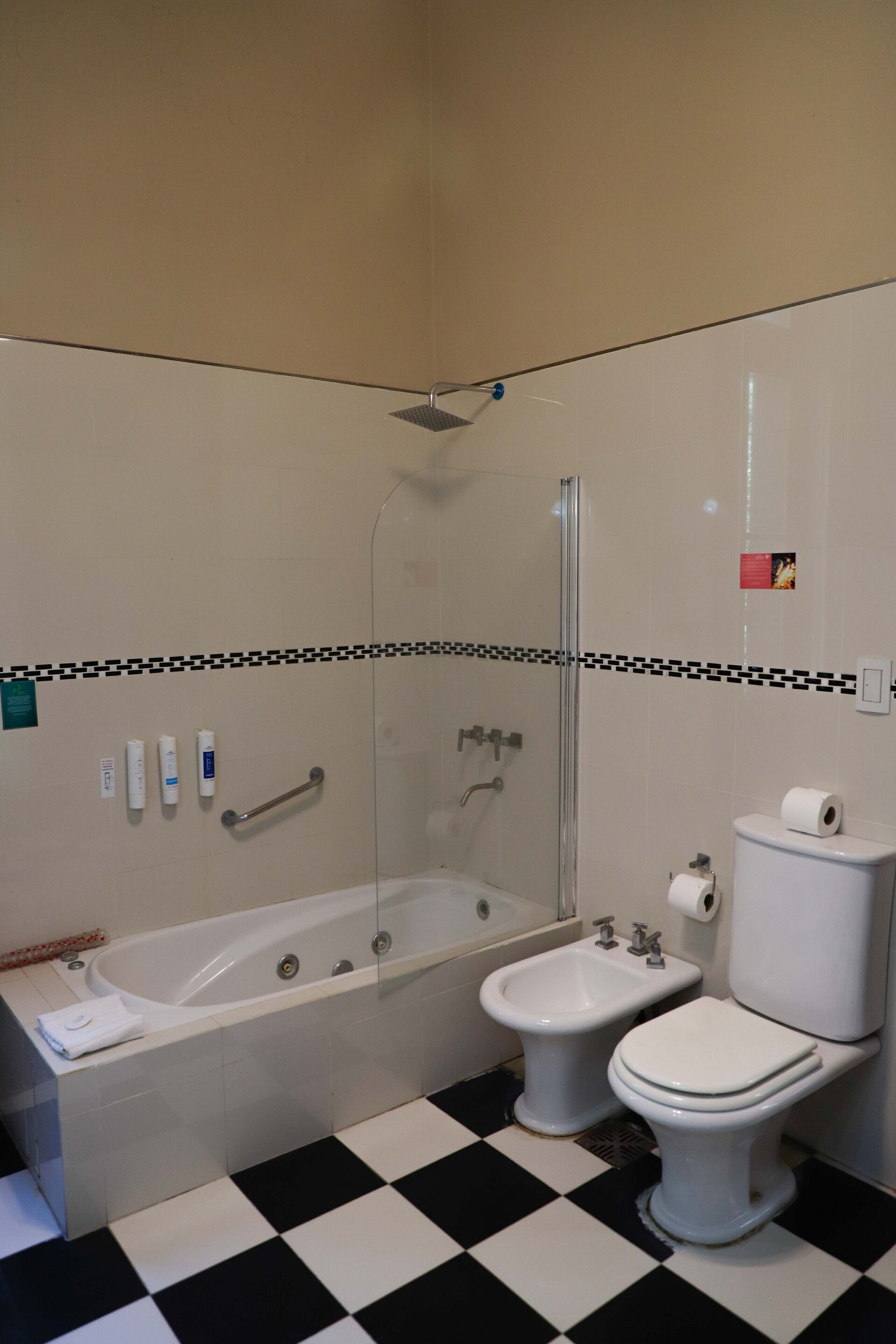 A bathroom with a bathtub, a bidet, and a toilet.