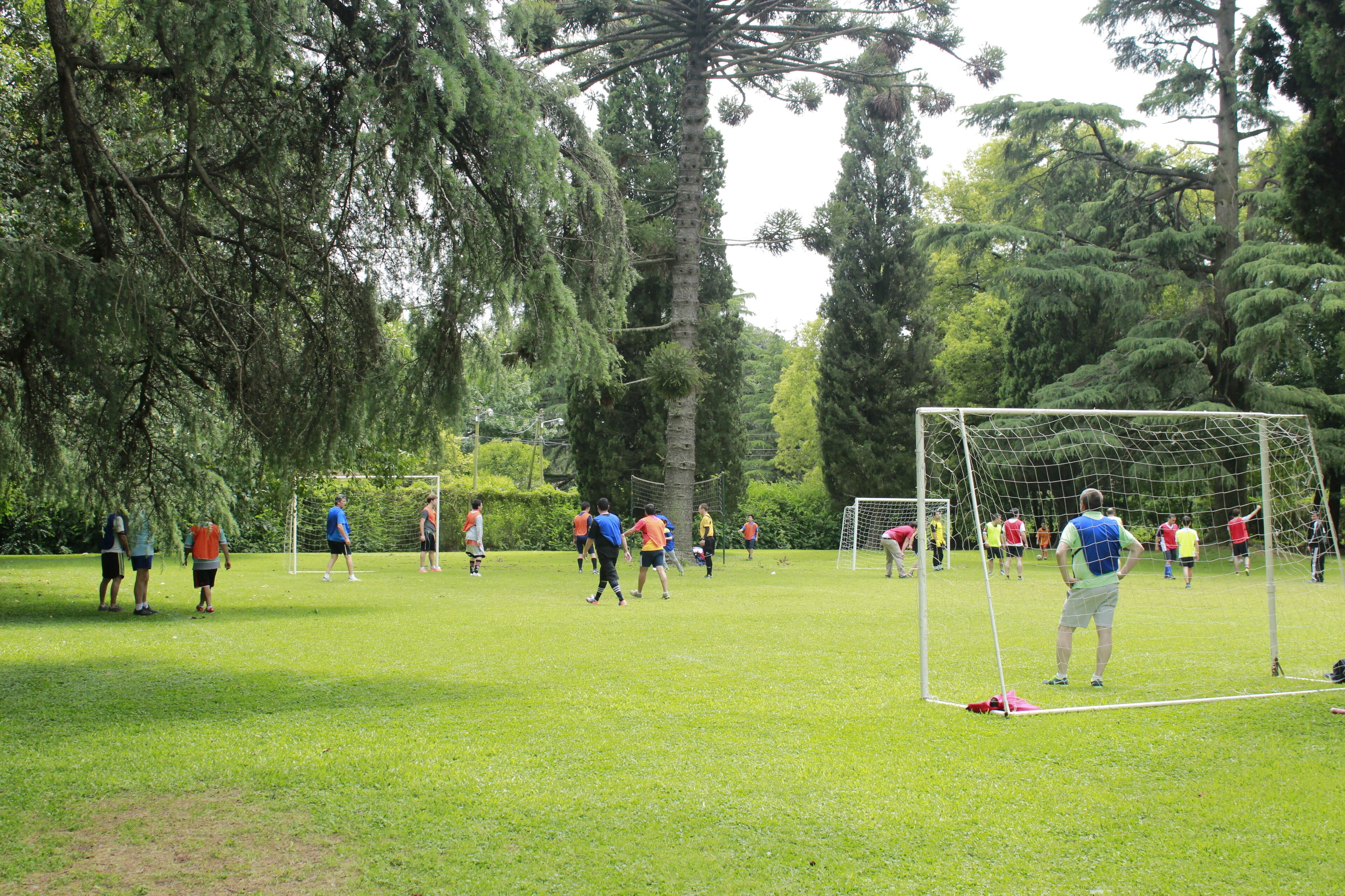 An outdoor soccer field with goalposts, surrounded by trees.
