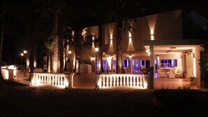 A modern hotel with a covered outdoor area, large windows, and a well-lit entrance. - Howard Johnson by Wyndham Escobar Hotel (Belen de Escobar)