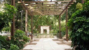 A garden with a stone pathway leading to a pergola structure. - Howard Johnson by Wyndham Escobar Hotel (Belen de Escobar)