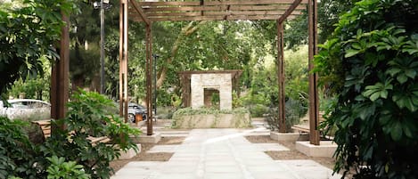 Un jardín con un sendero de piedra que conduce a una pérgola.