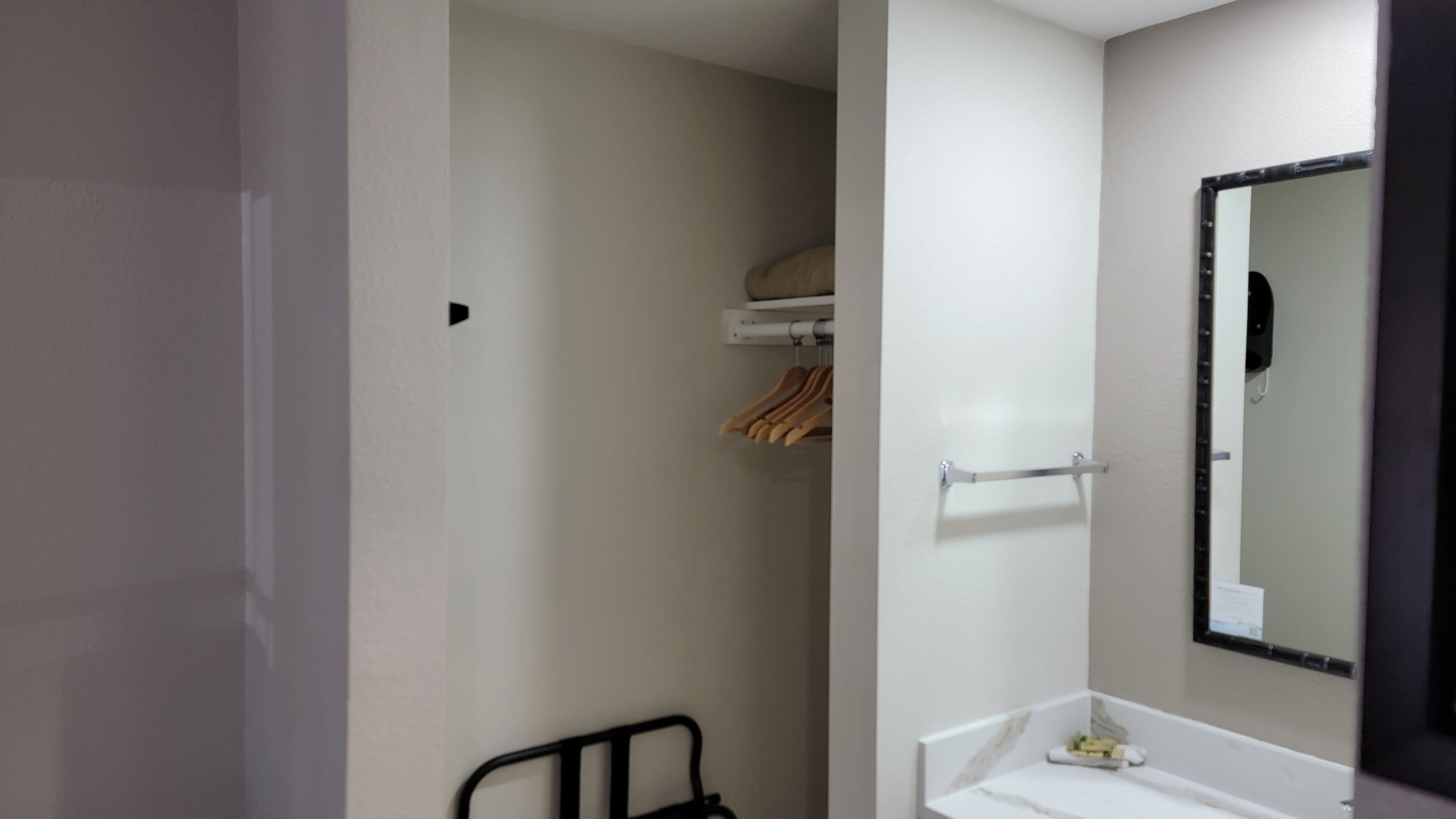 Ein Badezimmer mit einem weißen Waschbecken, einem Spiegel und einem Handtuchhalter.