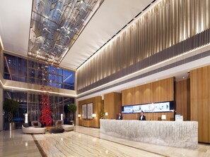 A modern hotel lobby with a reception desk, seating area, and a large glass ceiling. - Northern Hotel Shanghai (Shanghai)