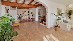 A spacious living area with a wooden ceiling, a dining area, and a cozy seating arrangement.