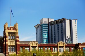 A historic building with a modern skyscraper adjacent to it.
